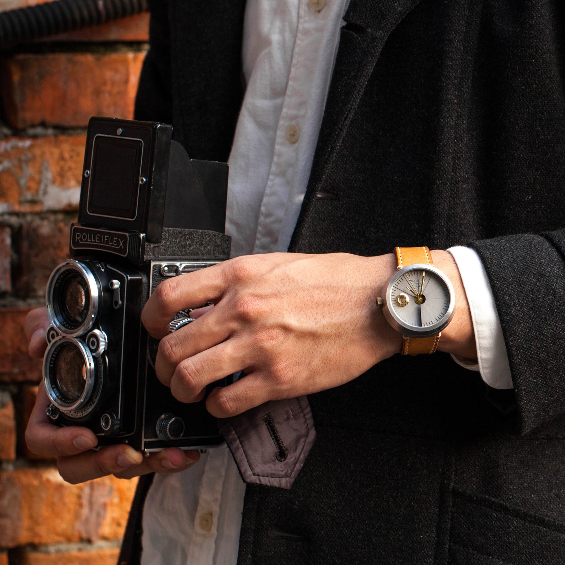 Man With An Old Camera Wearing A 22STUDIO 4D Concrete Automatic Watch